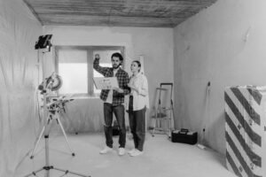 Interior designers discussing renovation plans in a room under construction.