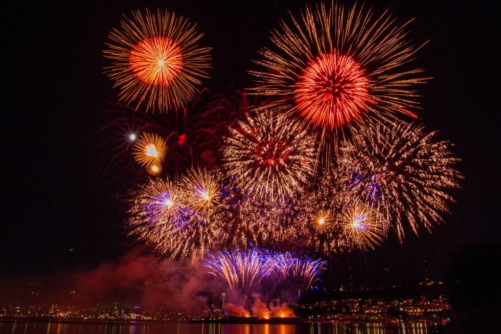 Vibrant fireworks illuminate the night sky over a bustling city, celebrating a special occasion.